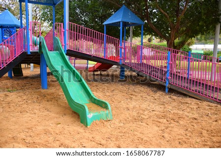 colorful empty children's playground in a park in the city. sliders in the sand. Royalty-Free Stock Photo #1658067787