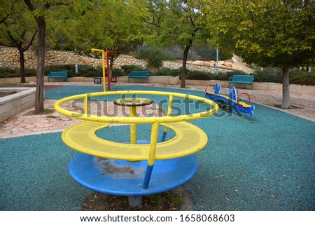 colorful empty children's playground in a park in the city. carousel and swings. Royalty-Free Stock Photo #1658068603
