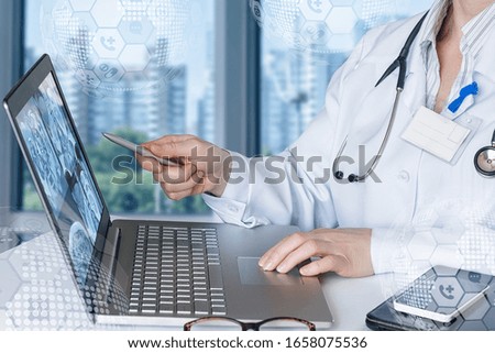 A doctor is studying magnetic resonance imaging images on a laptop.