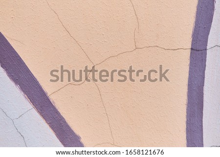 Abstract texture of plaster of beige color and lines of purple. Close up.