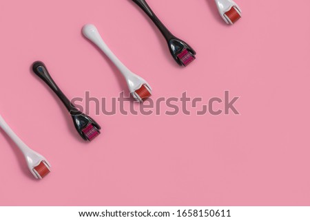 Top view of micro mesoroller derma roller for medical micro needling therapy on light pink background with copy space Royalty-Free Stock Photo #1658150611