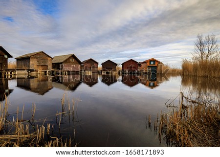 Neusiedler See, Lake Neusiedl. Bay with wooden pier and wooden cottage. Royalty-Free Stock Photo #1658171893