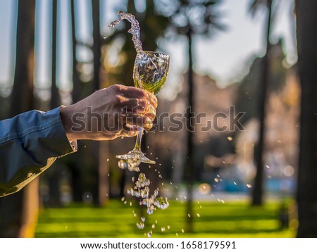 There is also water for the wine glass. young woman shakes the glass.