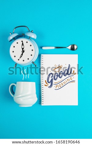 Coffee mug with notebook and clock with quote Good Morning