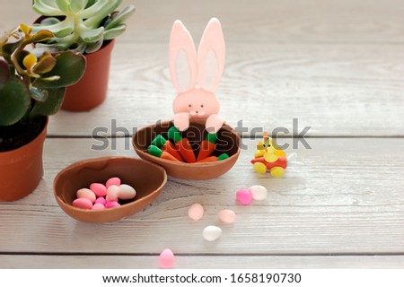 easter decorations. toy bunny, chicken and chocolate egg with carrot decor. succulent spring flowers. festive kids design for easter.