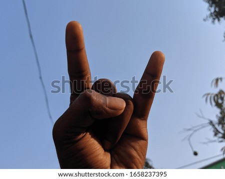 Chilling hand of a man with blue sky.