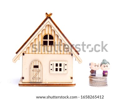 A picture of old people miniature on stack of coins and bokeh wooden house. It is for retirement and wealth plan concept.