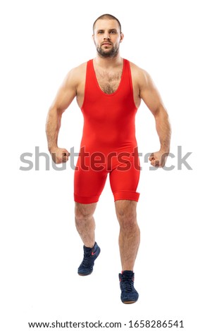 Strong strong young man in a sports red tights stands posing looking confidently ahead on a white isolated background. Concept of athlete, Greco-Roman wrestler for sports design.