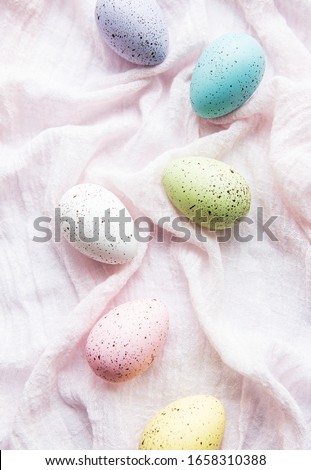 Colorful Easter eggs on pink fabric  background. Top view, flat lay.