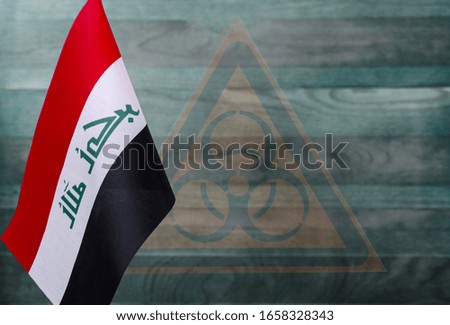 fragment of the flag of the Republic of Iraq on a blue background with a transparent biohazard sign