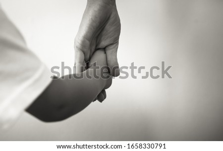 Little child holding mothers hand closeup. Parenting and child care concept.