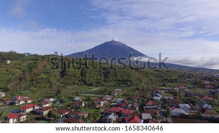 Kerinci is a volcano in Sumatra island of Indonesia. It is surrounded by the lush forest of Kerinci Seblat National Park, home to the endangered species of Sumatran tiger and Sumatran rhinoceros. Royalty-Free Stock Photo #1658340646
