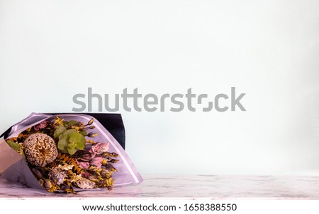 Original bouquet of fresh flowers on marble table on light background, close-up. Stylish tender decorative plants. Flowers for Men, Daddy's Day
