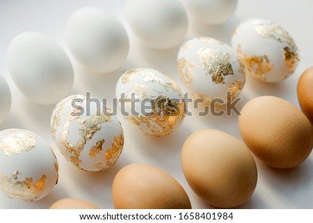 background of different eggs on a white background. eggs are white, brown and decorative gold. the concept of the Easter background. vintage tinting