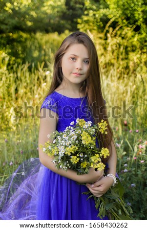
beautiful girl in blue in a botanical garden where a sea of ​​daisies