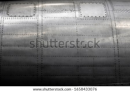Gray fuselage of a vintage aircraft background Royalty-Free Stock Photo #1658433076