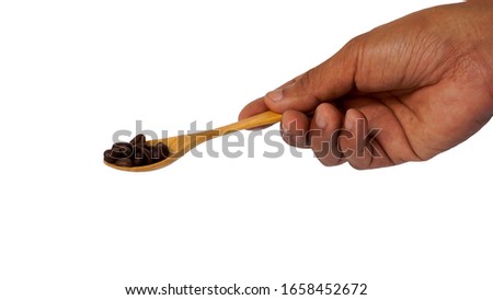 A picture of a wooden spoon in a coffee bean isolated on a white background