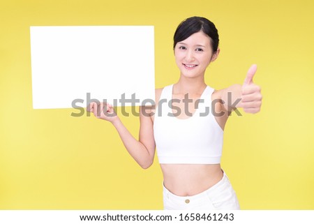 Smiling woman holding a whiteboard.