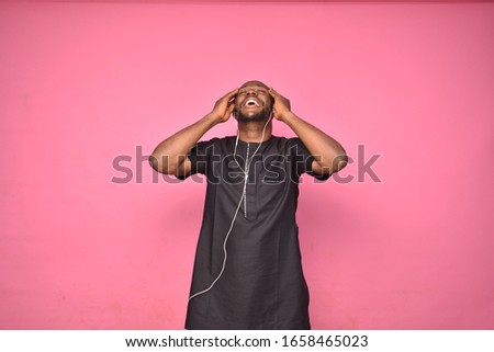 young handsome african man wearing african attire enjoy listening to music