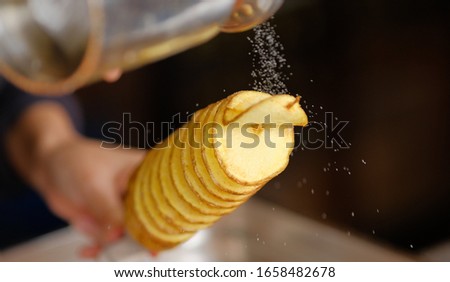 tornado potatoe on a stick being salted at a food store Royalty-Free Stock Photo #1658482678