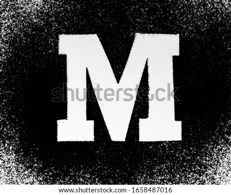 Latin alphabet letters drawn on a black background with powder
