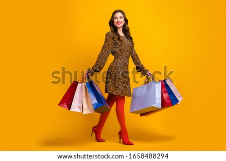 Full length body size view of her she nice attractive lovely fashionable cheerful cheery wavy-haired girl carrying new things walking isolated on bright vivid shine vibrant yellow color background
