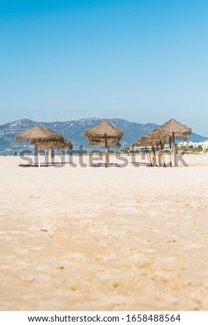 
Set of umbrellas on the beach with mountain in the background