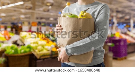 shopping, healthy eating and eco friendly concept - close up of woman with paper bag full of food over supermarket on background
