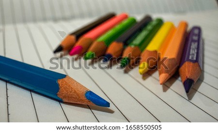 Close-up of a blue colored pencil is in front of other colored colored pencils