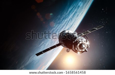 Spaceship in outer space near orbit of the Earth planet. Sun and stars on the background. Elements of this image furnished by NASA Royalty-Free Stock Photo #1658561458