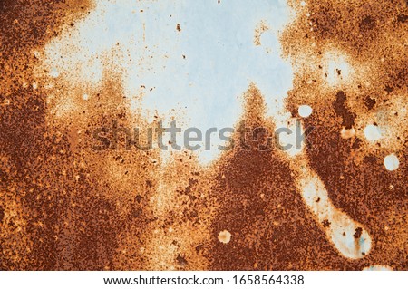 Abstract background. A large spot of light blue pastel paint on an old rusty metal surface. Background, structure.