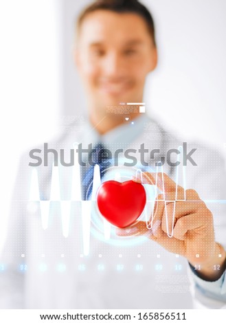 healthcare and medicine concept - male doctor with heart and cardiogram Royalty-Free Stock Photo #165856511