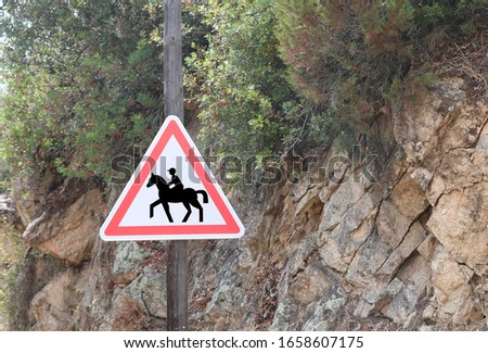 road sign with the symbol attention to the crossing of horses near an equestrian center