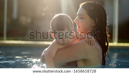 
Mother holding baby at the pool