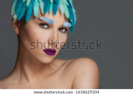 Closeup portrait of young beautiful woman with blue hair and eyebrows