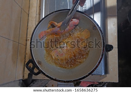 Fry tilapia in hot oil. Blurred picture of  cooking tilapia.