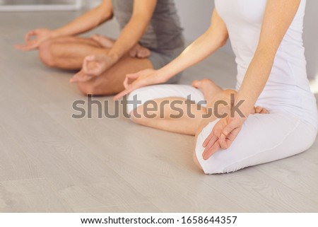 Close up of yoga couple people hand sitting relaxation in lotus field on floor in studio class.