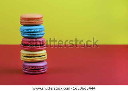 colored french macaroons on a red and yellow background