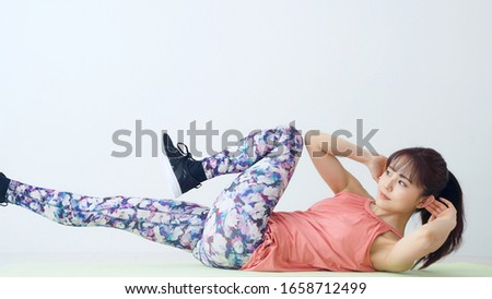Young asian girl training in the fitness gym. Twist crunch. Royalty-Free Stock Photo #1658712499