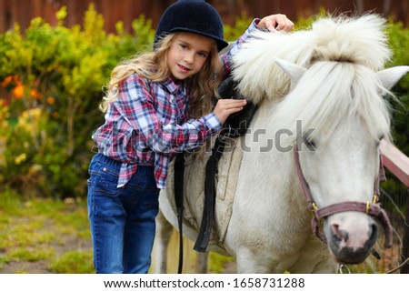 Portrait of little girl with her pony