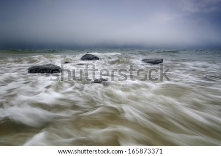 Picture of rocks flooded by coming wave. 