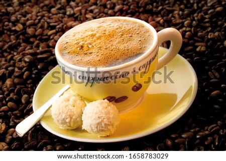 Cup of coffee atop a bed of coffee beans