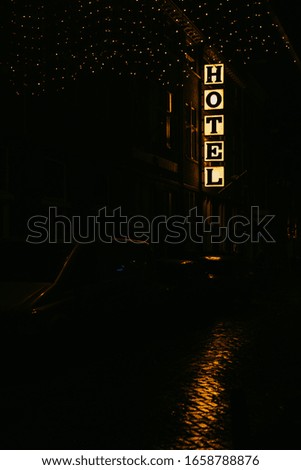 Hotel glowing sign at night. Tourism and travel. Convenient booking rooms. Night shot.