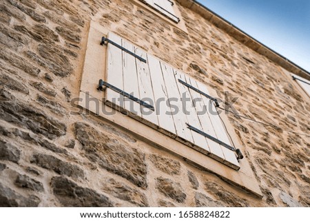 window with closed wooden shutters in the old stone town