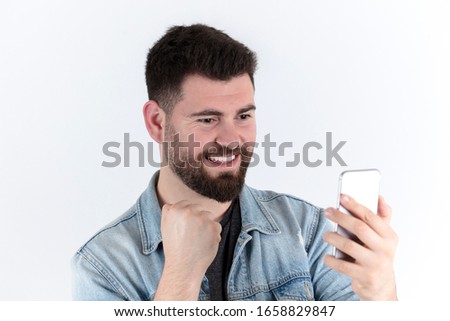 Happy male with smartphone celebrating success