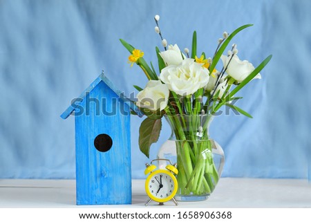 bouquet of spring flowers and a bright blue birdhouse on a blue background. picture for packages.Spring mood. Spring card for Mother's Day, Women's Day. Template greeting card .copy space.
