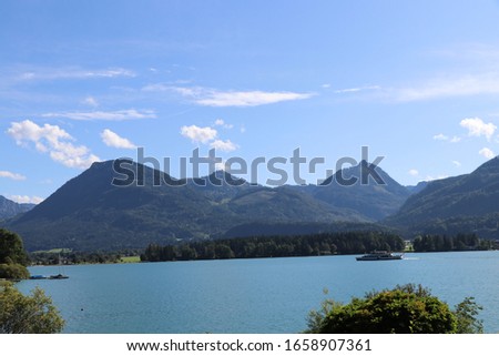 Blue sky and light cloud over Austrian mountain lake