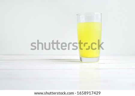 Glass of water with dissolved healthy vitamin tablet on white with copyspace