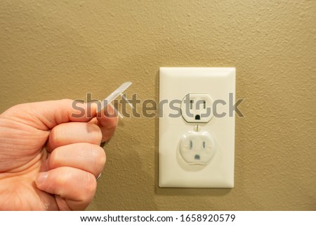 Electrical outlet with baby proof covers Royalty-Free Stock Photo #1658920579
