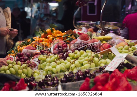 Stock photo of a market stand full of different seasonal fruits and agricultural products.